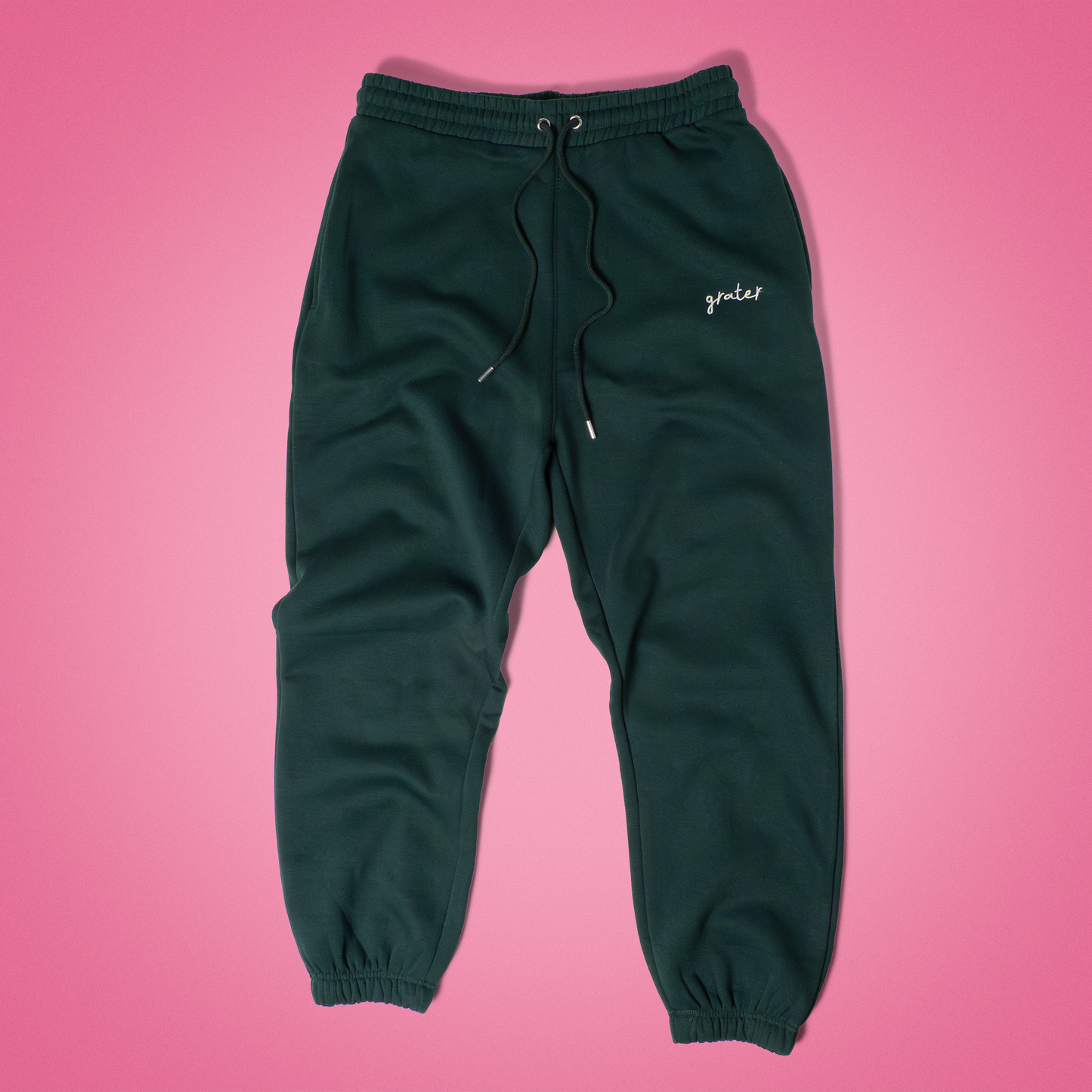 Deep forest green sweatpants with ‘Forest Fromage’ embroidery near the pocket, relaxed fit with elastic waistband and cuffs – earthy comfort meets cheese pun flair in this Grater Things essential.
