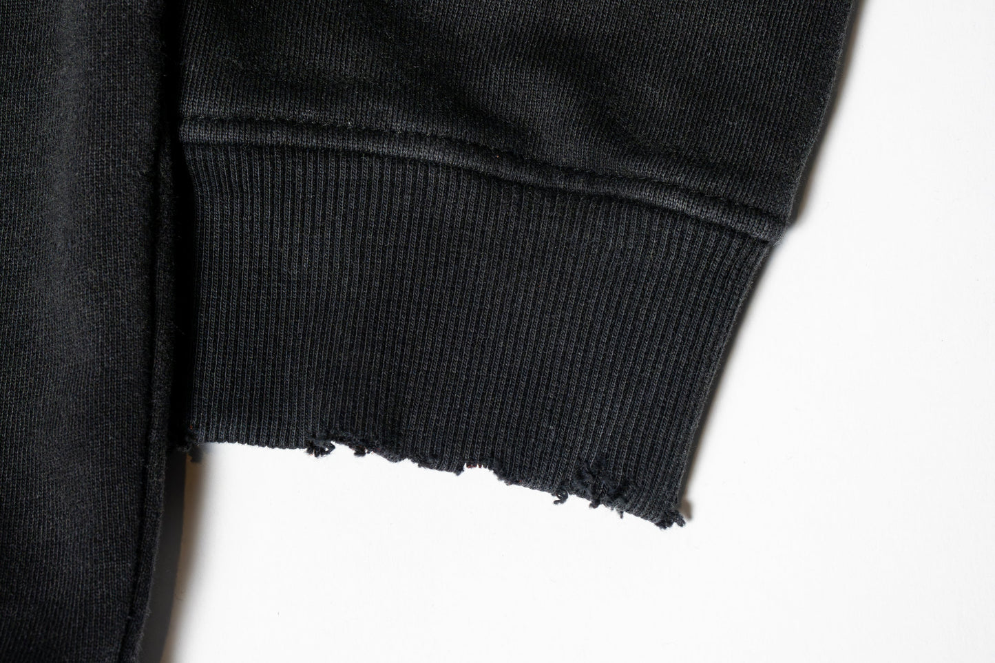 The sleeves carry a subtly grunge-inspired vibe, with a worn-in texture and relaxed structure that adds to the hoodie’s effortlessly edgy character.