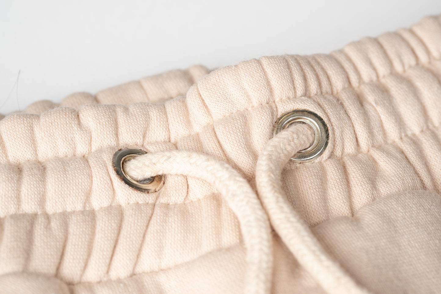Soft cotton drawstrings with metal eyelets for a clean, adjustable finish.