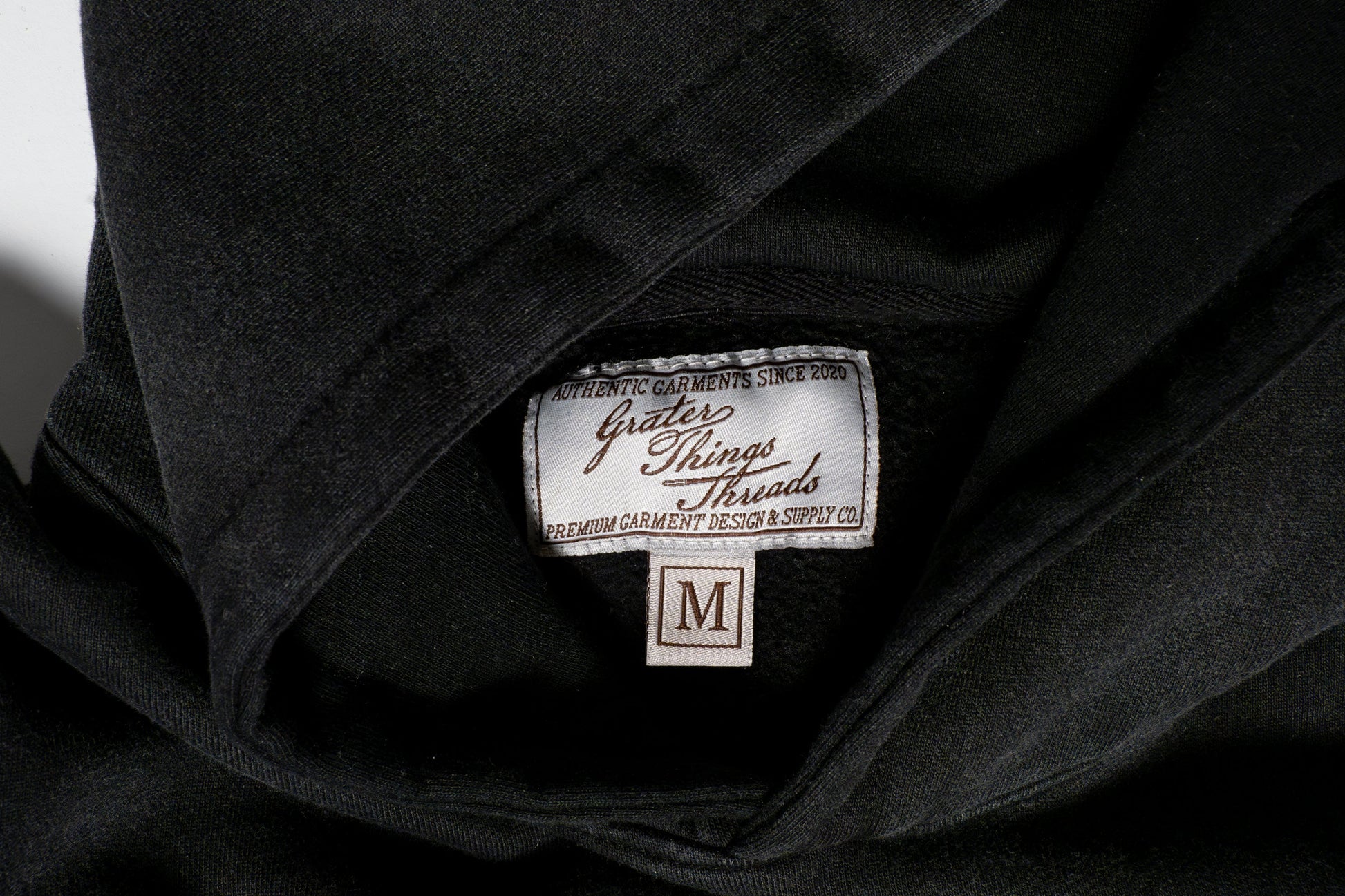The tag reads Grater Things Threads in clean lettering, stitched neatly into the inner collar  a subtle nod to comfort, quality, and cheesy charm.