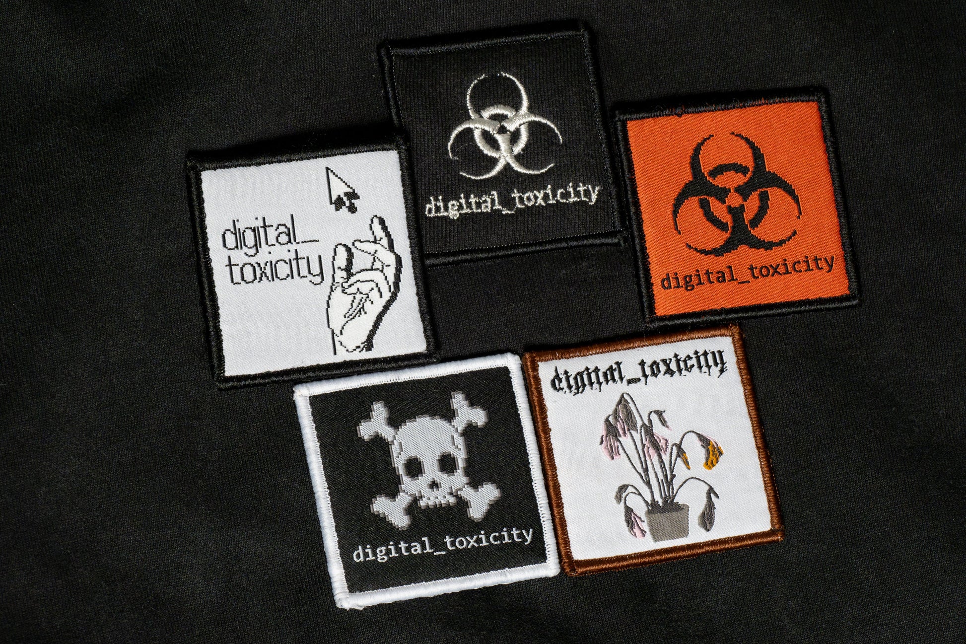The digital_toxicity hoodie features five distinct embroidered logos of Digital Toxicity, each with its own glitchy, cyberpunk-inspired design layered across the back like corrupted code, making a bold statement in every thread.