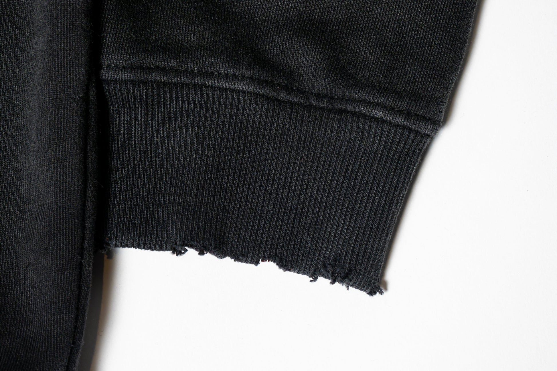 The sleeves carry a subtly grunge-inspired vibe, with a worn-in texture and relaxed structure that adds to the hoodie’s effortlessly edgy character.